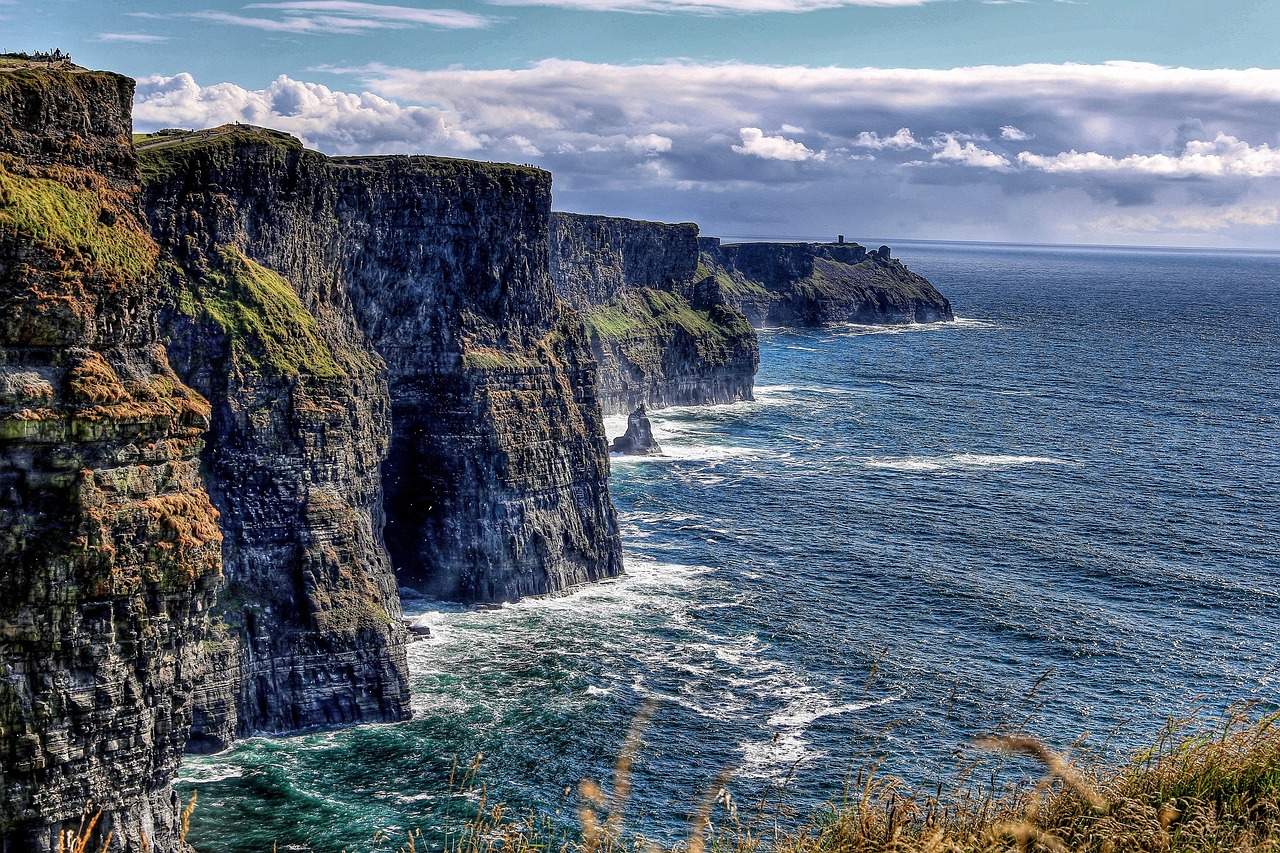 <p>Dopo la prima colazione irlandese, partenza alla volta del Burren, affascinante regione carsica dove l&rsquo;acqua, scorrendo in profondit&agrave;, ha creato grotte e cavit&agrave; sotterranee. &Egrave; la pi&ugrave; estesa regione di pietra calcarea d&rsquo;Irlanda e la particolarit&agrave; del suo territorio gli conferisce l&rsquo;aspetto di un terreno&nbsp;lunare. All&rsquo;interno di questo paesaggio particolare&nbsp;si trova Poulnabrone Dolmen: la testimonianza preistorica pi&ugrave; famosa del Burren. &Egrave; un dolmen che risale al 3800-3200 a.C. Continuazione attraverso la contea&nbsp; di Clare e sosta alle maestose ed imponenti Scogliere di Moher, alte 200 metri e lunghe 8 Km: sono uno spettacolo che lascia senza fiato. Pranzo libero. Visita al castello di Bunratty che&nbsp;comprende il complesso medievale pi&ugrave; completo ed autentico in tutta Irlanda. Fu costruito nel 1425 e restaurato definitivamente nel 1954. Il castello infatti aveva subito in molte occasioni saccheggi e distruzioni ma oggi lo possiamo ammirare nuovamente nel suo splendore medievale grazie all&rsquo;arredamento e alla tappezzeria che richiama lo stile di quel periodo. Il Folk Park intorno al castello ricostruisce la vita rurale nell&rsquo;Irlanda di 100 anni fa, con le sue fattorie&nbsp;appositamente ricostruite, cottage e negozi, ricreati con la massima cura e con particolare attenzione soprattutto all&rsquo;arredamento. Si prosegue poi verso la Contea del Kerry passando per il paesino di Adare. Tempo permettendo, effettueremo una breve sosta.&nbsp;Cena e pernottamento nella contea di Kerry</p>